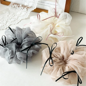 Texture détaillée de chouchous en tulle en blanc crème, gris fumé et couleur champagne