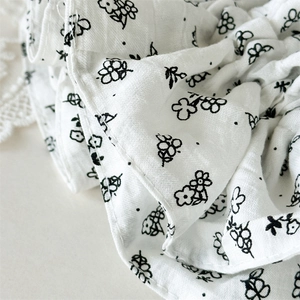 Gros plan d'un chouchou en coton blanc avec des détails de motifs floraux noirs délicats