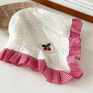 Detail of baby sun hat with white eyelet fabric, cherry embroidery, and red gingham ruffle