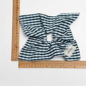 Large plaid scrunchie with green check pattern shown flat on a white background with ruler