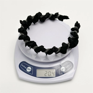 Elegant black pleated headband with silver rhinestones on a scale showing 20.4g weight