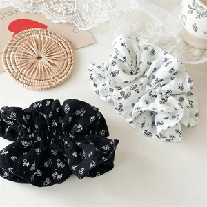 Grands chouchous en coton à fleurs noir et blanc sur un fond de décor élégant