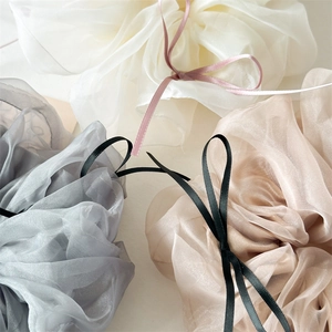 Détail de chouchous en organza doux avec des nœuds élégants aux couleurs neutres raffinées