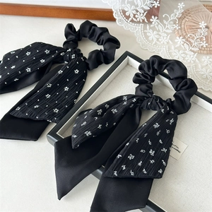 Floral black layered scrunchie with long bow ribbon on an elegant tray background