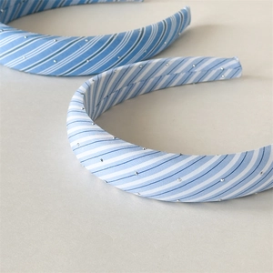 Detailed view of blue and white plaid sponge headband featuring silver micro-bead accents