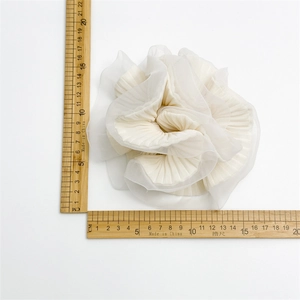 Detail view of a 13cm white pleated organza scrunchie with measuring ruler shown