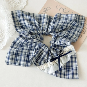 Detail of blue plaid hair scrunchie with lace trim and elegant navy ribbon bow