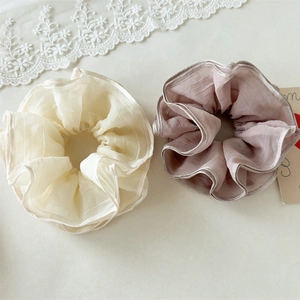 Close-up of fluffy multilayer mesh scrunchies in beige and dusty pink organza fabric