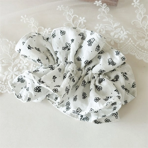 Détail du chouchou floral coréen en tissu de coton blanc avec motifs de fleurs noires