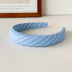 Macro shot of light blue plaid headband with small silver studs and textured fabric detail