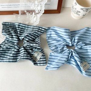 Detail of blue striped cotton hair scrunchies with HAND MADE fabric labels in a cozy setting