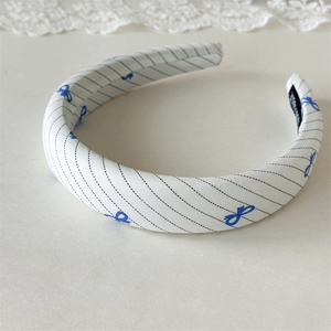 Detail of blue bow print fabric headband with soft white texture and non-slip lining
