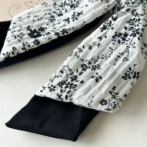 Detail of black and white floral print scrunchie with seersucker pleated texture fabric