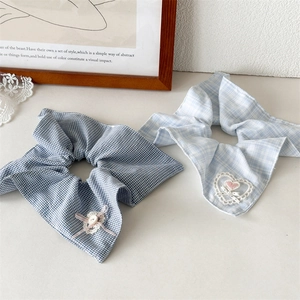 Vue détaillée de chouchous à carreaux bleus avec broderie coeur en dentelle et volants