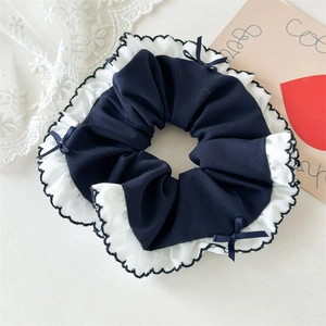 Detail of blue plaid hair scrunchie with white lace edges and small bow decoration