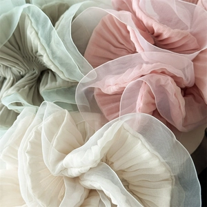 Macro shot of large organza hair scrunchies showing pleated texture and pastel colors