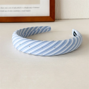 Close-up of blue plaid sponge headband with silver stud accents and non-slip lining