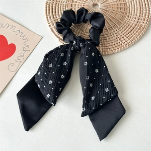 Detail of floral black double-layer ponytail scrunchie with soft pleated texture