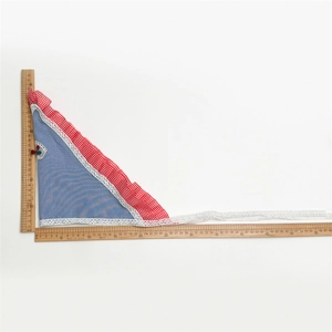 Detail view of denim blue headscarf featuring red cherry embroidery and white lace edges
