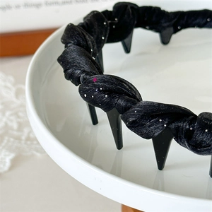 Detail of black twisted fabric headband with glitter and non-slip inner teeth