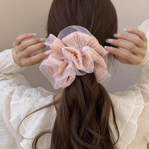 Detail of elegant pink organza hair scrunchie with layered pleats on a ponytail