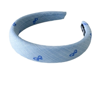 Light blue wide fabric headband featuring navy bow patterns and handmade woven texture