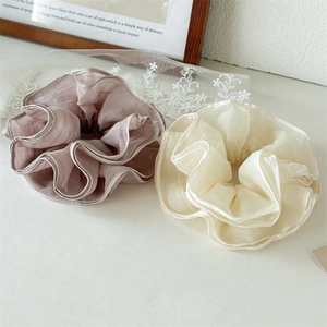 Close-up of elegant mesh scrunchies in dusty pink and cream white with delicate pleats