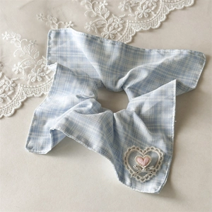 Détail de chouchou à carreaux bleus avec cœur brodé en dentelle et nœud en perles
