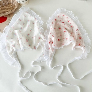 Detailed view of red cherry and floral lace head scarves with delicate mesh ribbons