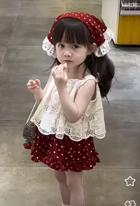 Detailed view of kids vintage red polka dot headband paired with a white lace top