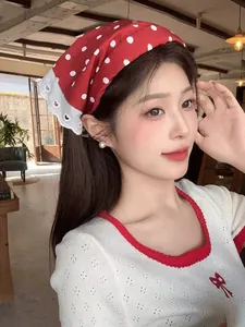 Close-up of vintage red polka dot bandana with white lace edge detail on a woman