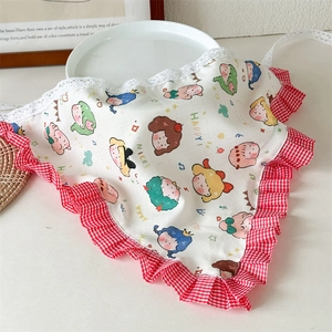 Détail d'un bandana triangle en coton avec motifs cartoon et bords en dentelle vichy rouge