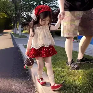 Detail of red polka dot layered skirt and white lace top for a girls summer set