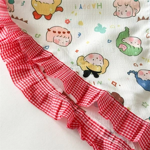 Détail de bordure à volants vichy rouge et imprimé dessin animé sur bandeau coton