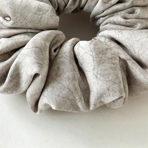 Detailed macro view of the marble texture on a grey elastic fabric scrunchie