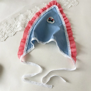 Detail of denim blue headband with red cherry embroidery and delicate lace trim