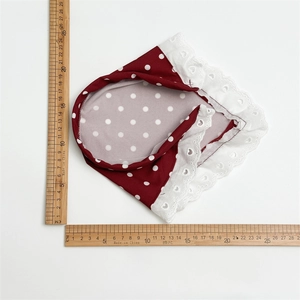 Red polka dot hairband with white lace trim shown against a ruler for size reference