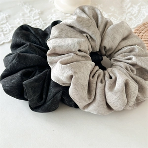 Set of two textured fabric scrunchies in black and light grey with marbled pattern