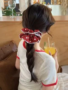 Detailed close-up of a vintage red polka dot scrunchie with white piping on its edges
