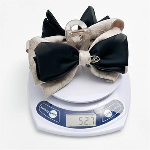 Elegant oversized ribbon bow hair claw clip in black and marble pattern on a scale