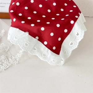 Detail of red polka dot satin headband with heart pattern lace trim and embroidery