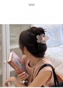 Détail d'une pince à cheveux florale crémeuse utilisée dans un chignon à la française