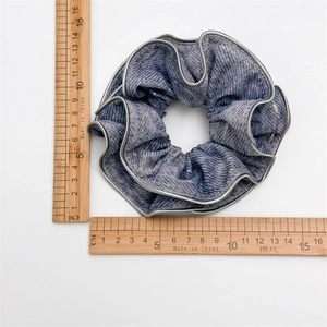 Detail shot of blue oversized scrunchie with silver glitter thread and 12cm diameter scale