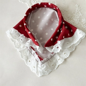 Detailed view of red polka dot headband with intricate white lace embroidery trim