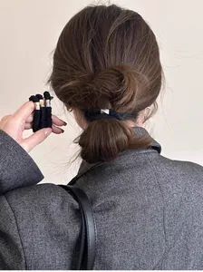 Détail d'un élastique à cheveux noir haute élasticité avec boucle métallique en queue