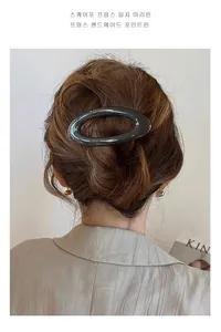 Detail van de donkergrijze ovale haarklem van hars gedragen op een knot in een Franse stijl