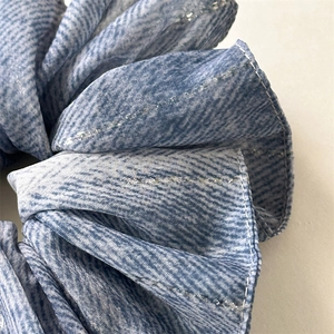 Detailed macro view of blue textured scrunchie with sparkling silver metallic thread