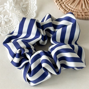 Détail d'un chouchou à rayures bleues et blanches sur un fond décoratif élégant