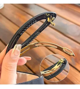 Close-up van zwarte haarklem met antislip tanden en gouden metalen scharniersluiting