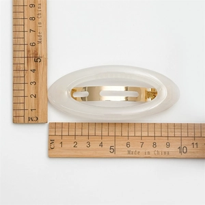 Elegante ovale haarclip in gelei wit voor dames met 9 cm maataanduiding display